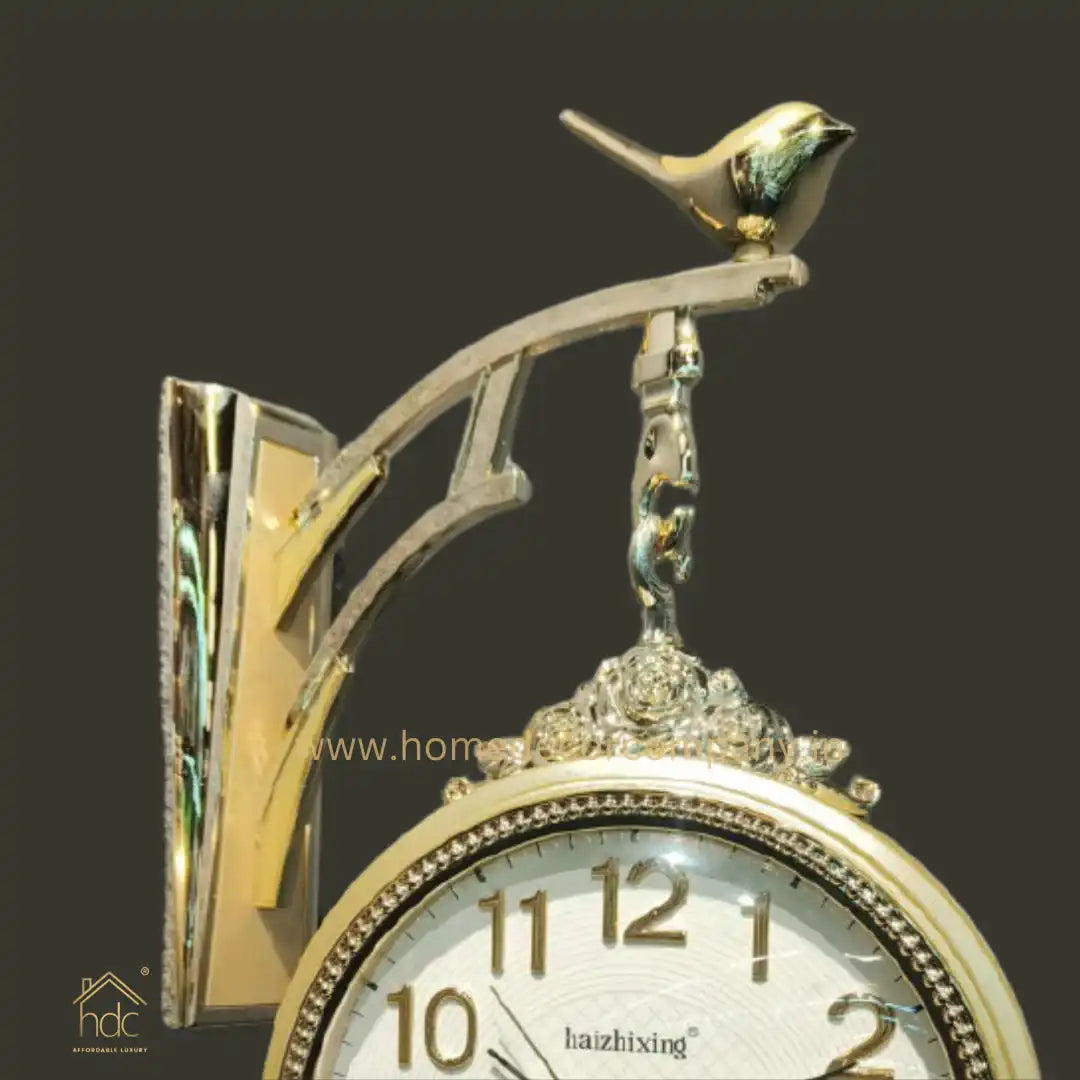 HDC Modern Double-Sided Wall Clock With a Decorative Golden Frame With Gold Accents, a Bird-Shaped Ornament on Top