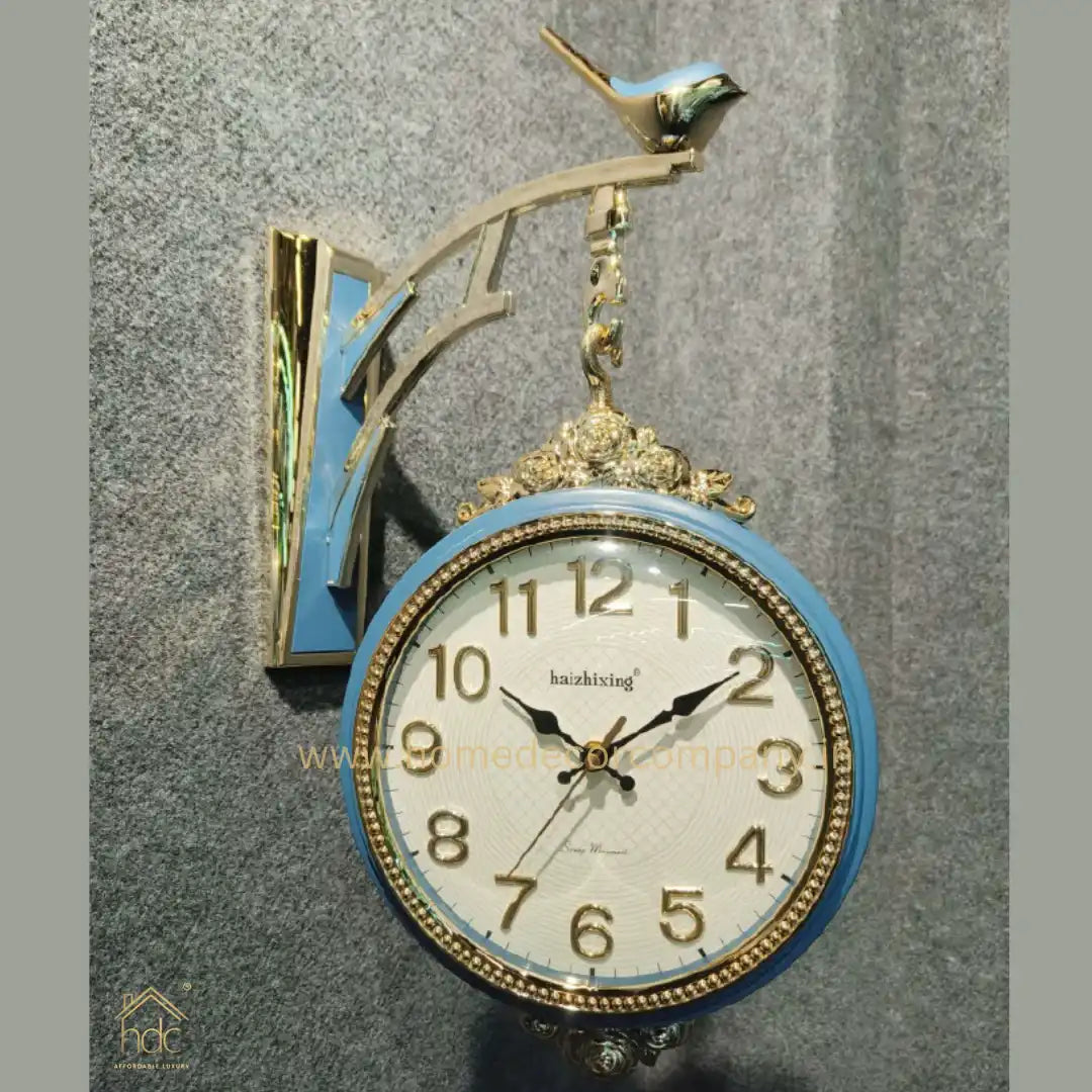 HDC Modern Double-Sided Wall Clock With a Decorative Light Blue Frame With Gold Accents, a Bird-Shaped Ornament on Top