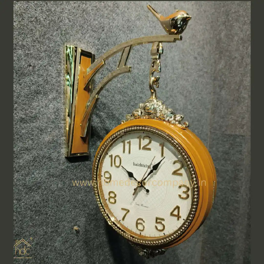 HDC Modern Double-Sided Wall Clock With a Retro Design Wooden clock face with black hands and gold-colored numerals, encased in a Wooden frame with gold detailing a Bird-Shaped Ornament on Top