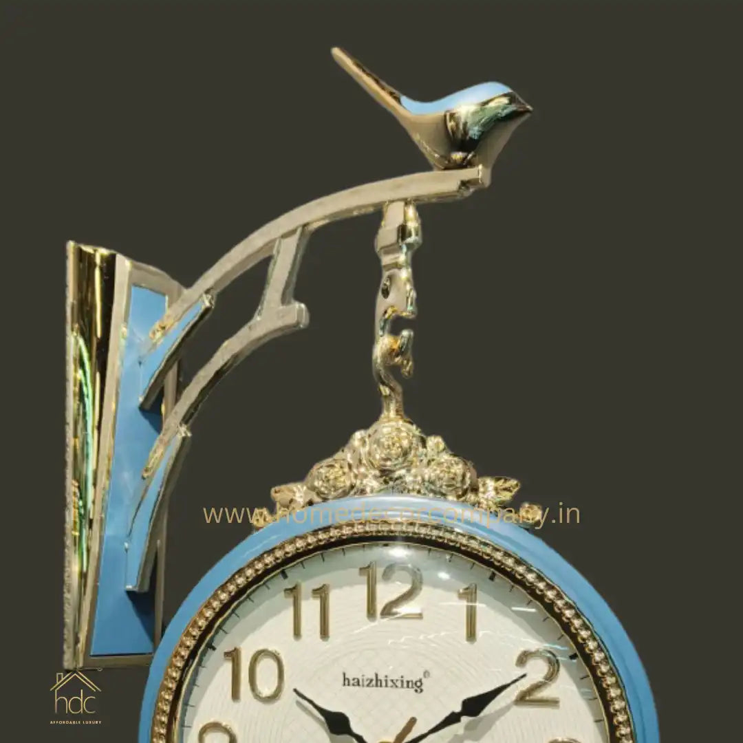 HDC Modern Double-Sided Wall Clock With a Decorative Light Blue Frame With Gold Accents, a Bird-Shaped Ornament on Top
