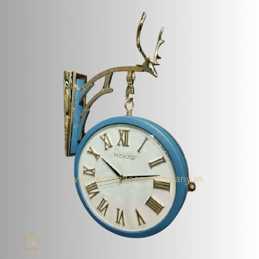 HDC Modern Double-Sided Vintage-Style Station Clock With a Decorative Reindeer Design blue frame, a white face with Roman Numerals, and Black Hands. The mount is gold and shaped like Reindeer Antlers